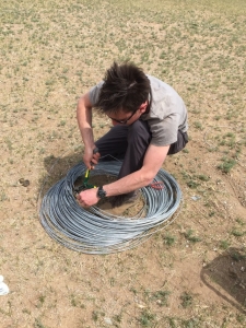 Andreas cutting a coil of number 8 into 1m stakes for off-road flagging.