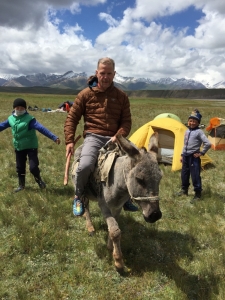 Grant amusing the local kids by riding their donkey
