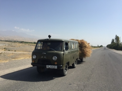 A classic Russian vehicle towing a haystack
