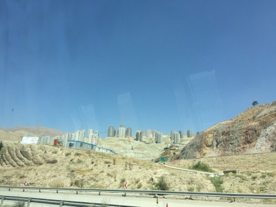 Half-completed high-rise apartment blocks as far as the eye can see on the way into Tehran